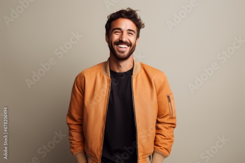 Portrait of a happy man in his 30s wearing a trendy bomber jacket against a minimalist or empty room background. AI Generation