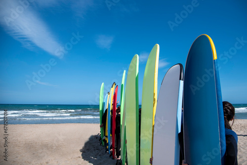 Set of different color surf boards in a sandy. Surf boards for rent on sandy beach. Soft toned photo.