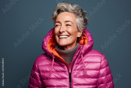 Portrait of a cheerful woman in her 60s sporting a quilted insulated jacket against a solid color backdrop. AI Generation