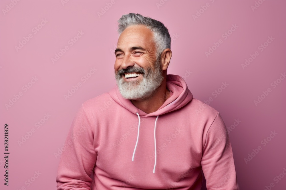 Portrait of a happy man in his 50s sporting a comfortable hoodie against a solid pastel color wall. AI Generation Portrait of a happy man in his 50s sporting a comfortable hoodie against a solid pastel color wall. AI Generation