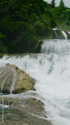 Aerial perspective view of majestic Aliwagwag Falls. Beautiful waters flowing. Mindanao, Philippines. Slow Motion. Vertical. photo