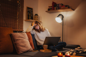 Frustrated tired young woman in front of a laptop during the Christmas holidays.