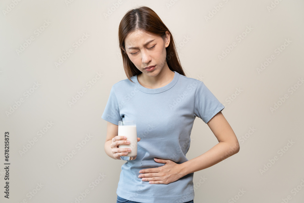 lactose intolerance concept. Woman holding a glass of milk and having a stomachache. lactose intolerance concept. Woman holding a glass of milk and having a stomachache.
