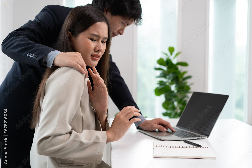 Sexsual harassment in workplace. Unhappy female employee looking at hand of boss touch at her shoulder and feeling disgusted. Sexsual harassment in workplace. Unhappy female employee looking at hand of boss touch at her shoulder and feeling disgusted.