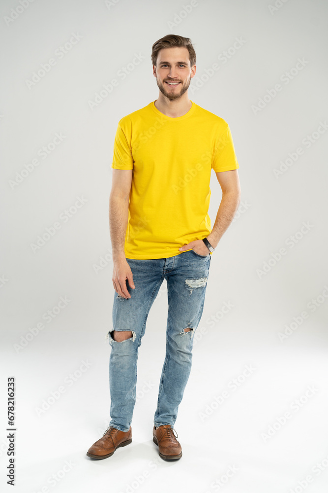 Full length portrait of happy handsome young man in yellow t-shirt isolated on white background. Full length portrait of happy handsome young man in yellow t-shirt isolated on white background.