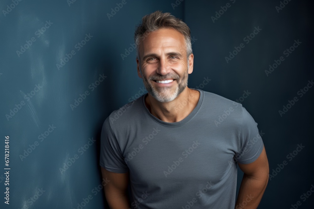 Portrait of a smiling man in his 50s dressed in a casual t-shirt against a bare monochromatic room. AI Generation Portrait of a smiling man in his 50s dressed in a casual t-shirt against a bare monochromatic room. AI Generation