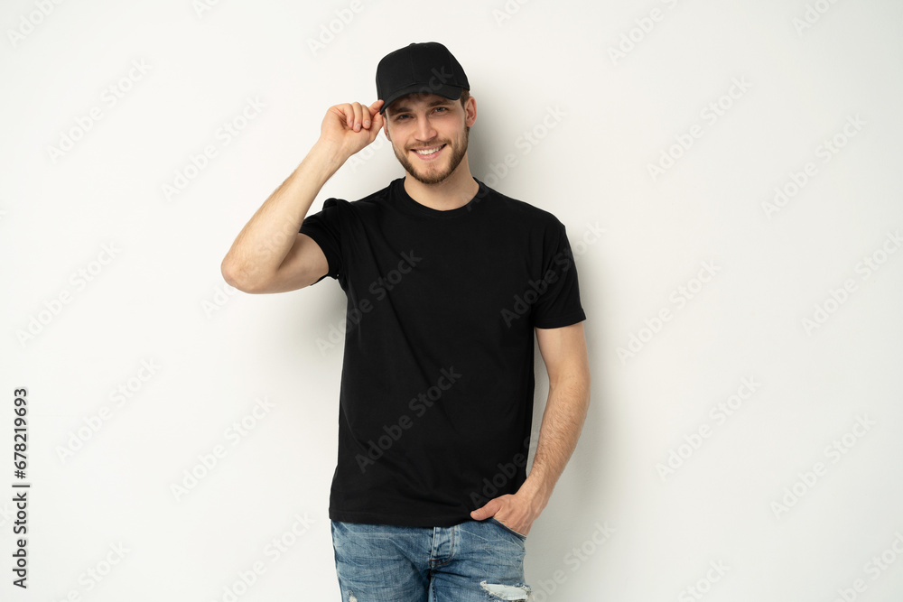 Portrait of happy casual man smiling, guy wearing black t-shirt an d cap at white wall, Isolated on white background Portrait of happy casual man smiling, guy wearing black t-shirt an d cap at white wall, Isolated on white background
