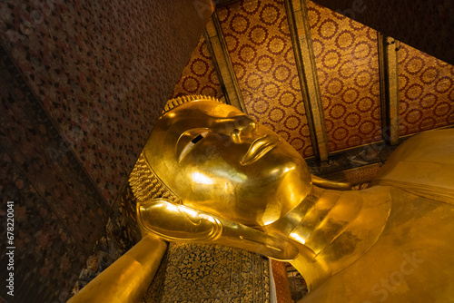 A close up of Reclining Buddha gold statue face. Wat Pho, Bangkok, Thailand photo