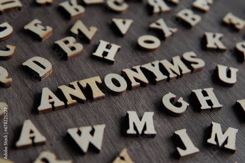 Closeup image of text ANTONYMS surrounded by scattered alphabet. photo