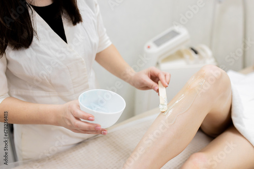 Laser epilation and cosmetology in beauty salon. Hair removal procedure. Laser epilation  cosmetology  spa  and hair removal concept. Beautiful woman getting hair removing on legs