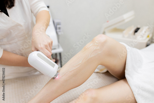 Laser epilation and cosmetology in beauty salon. Hair removal procedure. Laser epilation, cosmetology, spa, and hair removal concept. Beautiful woman getting hair removing on legs