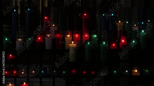 Burning colorful votive candles in a dark church in Barcelona, Spain