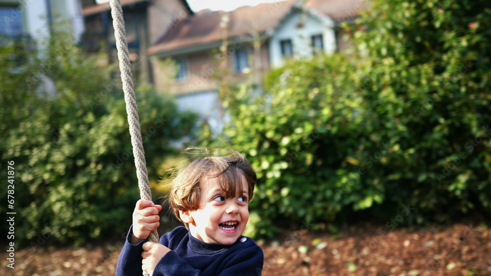 Excited Child Enjoying Rope Slide Amidst Fall Foliage, Joyful Caucasian Child Sliding Down Rope Between Trees in Autumn