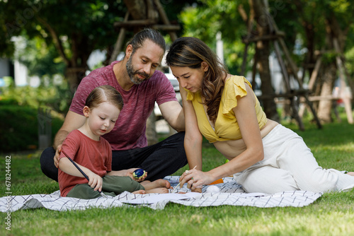 Happy family day, father, mother, son, Caucasian enjoying watercolor painting and picnic in nature. © atitaph