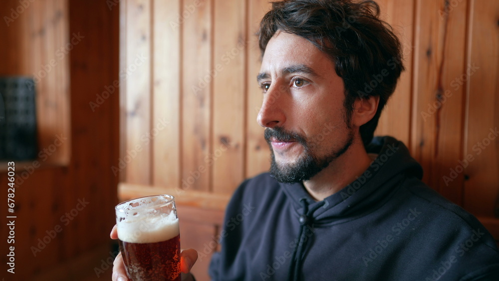 Man drinking draft beer in wooden restaurant Man drinking draft beer in wooden restaurant