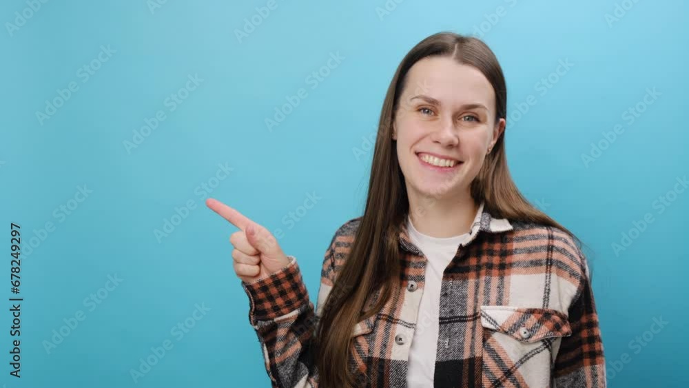 Promoter happy young caucasian woman wearing casual shirt pointing indicate index finger aside on workspace area copy space mock up, posing isolated over pastel blue color background wall in studio Promoter happy young caucasian woman wearing casual shirt pointing indicate index finger aside on workspace area copy space mock up, posing isolated over pastel blue color background wall in studio