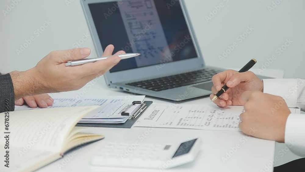 Hands of recruiter holding resume in front of candidate at desk Hands of recruiter holding resume in front of candidate at desk