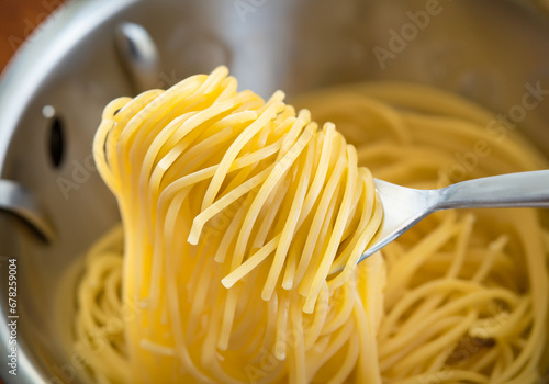  spoon scooping spaghetti in colander.