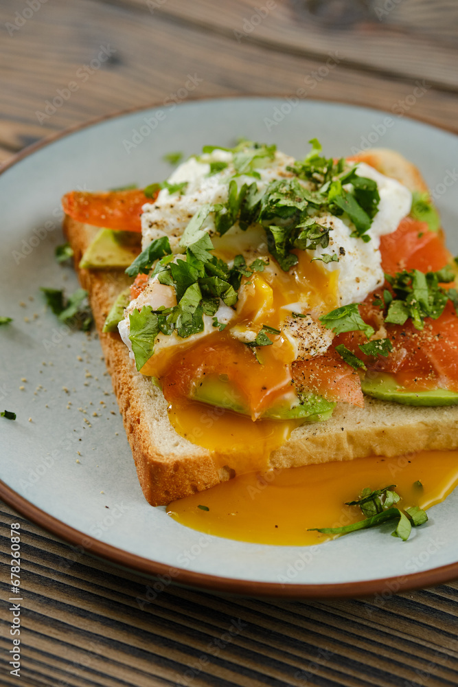 Closeup view of sandwich with trout, avocado and poached egg