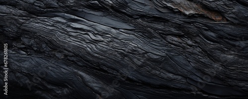 A macro shot of a black lava stone surface with an abstract twist, emphasizing the natural imperfections and visual interest of the material.