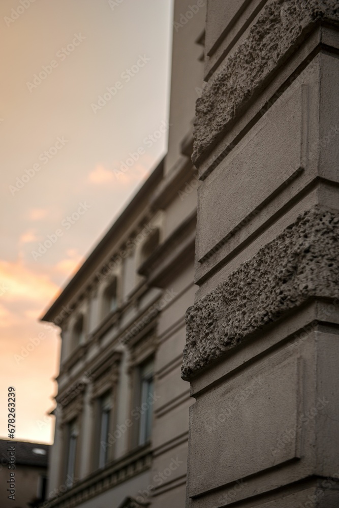 Obraz premium Vertical close-up of the exterior wall of the building at sunset with a cloudy sky in the background