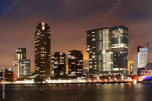 City buildings of Rotterdam at night in front of the sea, the Netherlands © Wirestock