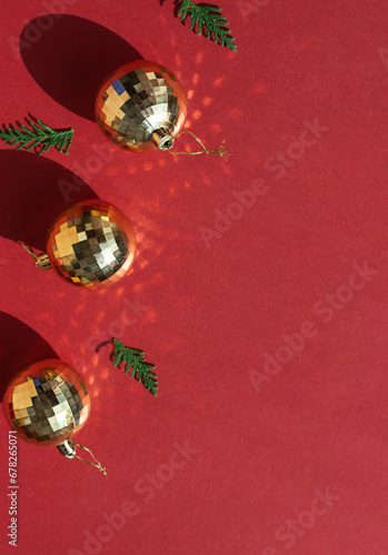 Golden shiny Christmas tree decoration baubles on the red background. Copy space photo