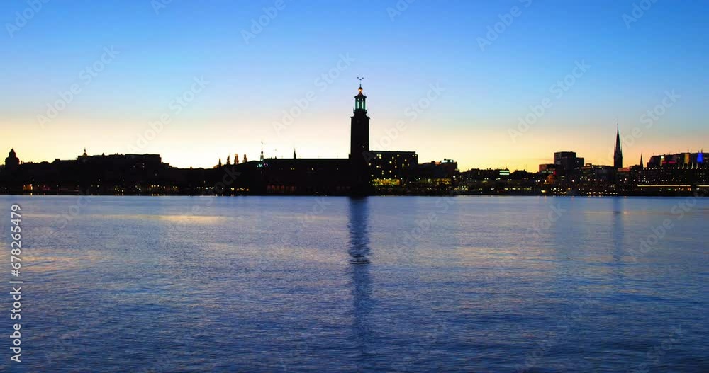 Aerial: Drone Forward Shot Of City Hall Amidst Buildings Near Sea In City Against Blue Sky - Stockholm, Sweden Aerial: Drone Forward Shot Of City Hall Amidst Buildings Near Sea In City Against Blue Sky - Stockholm, Sweden