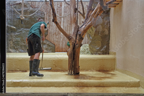 Animal keeper cleans an animal enclosure