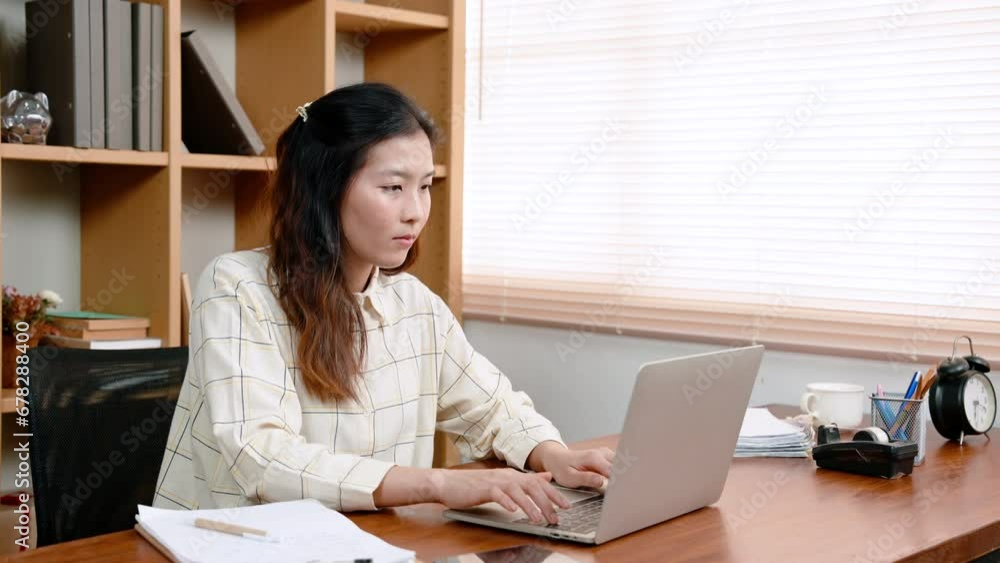 Asian female office worker puzzled expression as sits at desk with laptop computer in front, woman shuts down laptop computer, headache from difficult work uses both hands massage head for relief. Asian female office worker puzzled expression as sits at desk with laptop computer in front, woman shuts down laptop computer, headache from difficult work uses both hands massage head for relief.