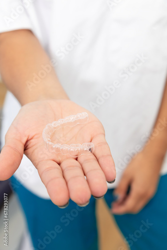 close up woman hand holding dental aligner retainer (invisible) dental treatment course concept
 (ID: 678293077)
