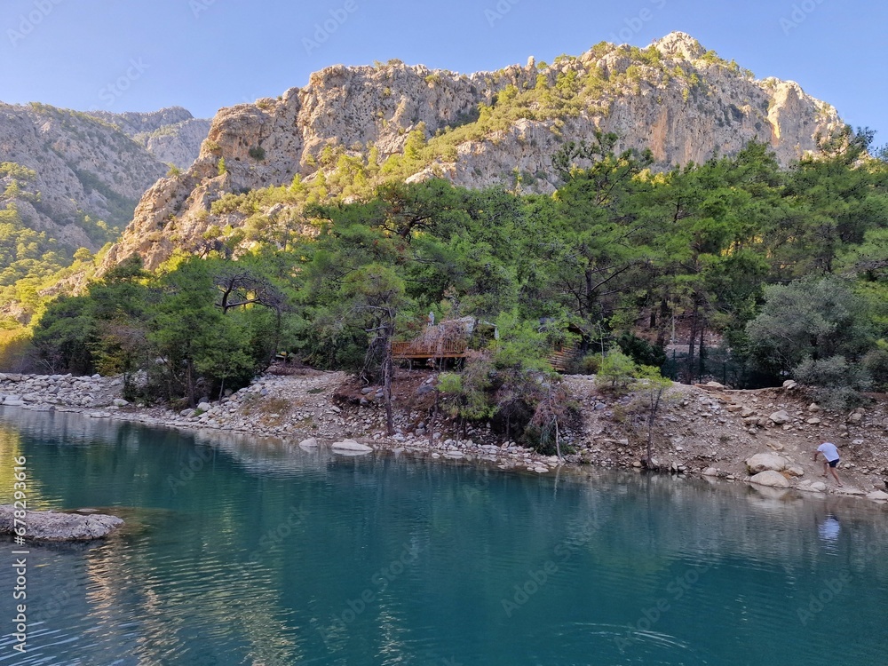 Stones along the coastline of a lake before the valley on a sunny day Stones along the coastline of a lake before the valley on a sunny day