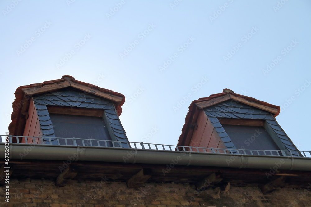 Two dormer windows on an old, decaying brick building Two dormer windows on an old, decaying brick building