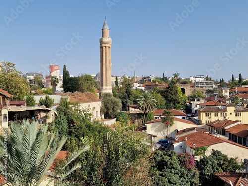 View of the Yivliminare Mosque minaret and cityscape before a blue skyline © Wirestock