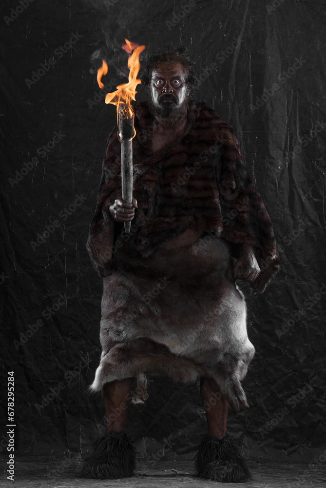 Fototapeta premium caveman with a torch, black background