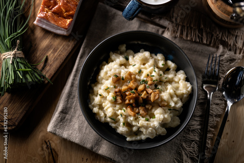 Halusky as traditional Slovak potato gnocchi with sheep cheese bryndza, fried bacon and chives photo