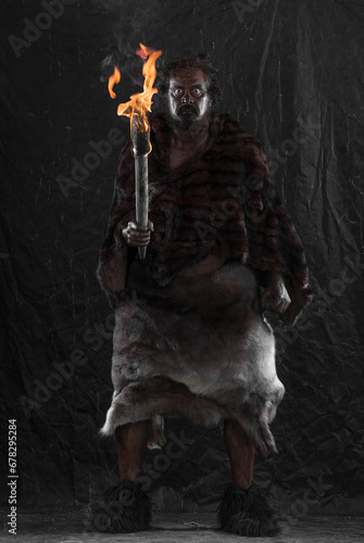 caveman with a torch, black background © serikbaib