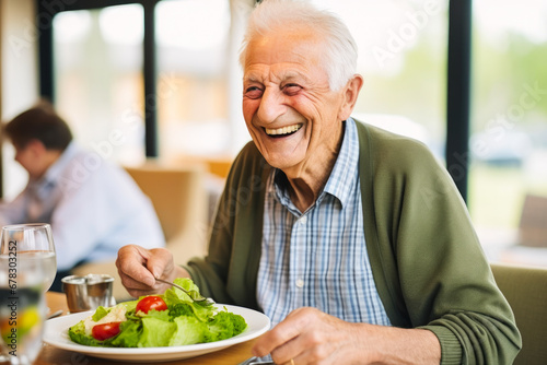 Senior man in a retirement home happily enjoying a healthy lunch. A showcase of a lifestyle of well-being and contentment