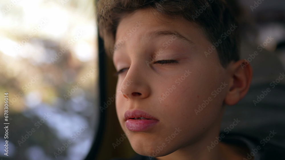 Child feeling bored shaking head in boredom while traveling by train sitting by window staring with blank face at landscape pass by while feeling upset in boredom Child feeling bored shaking head in boredom while traveling by train sitting by window staring with blank face at landscape pass by while feeling upset in boredom