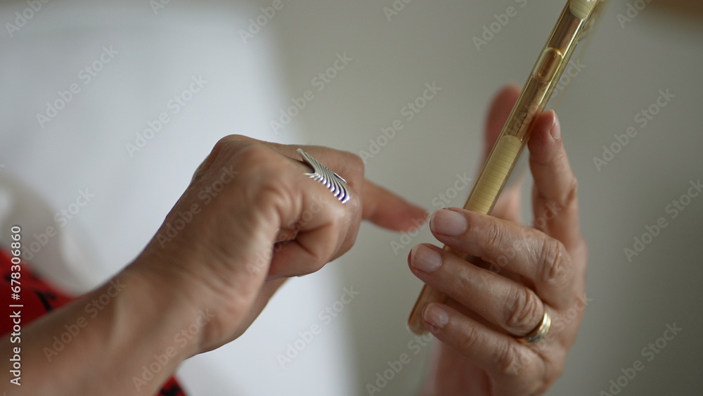 Close-up senior hands holding cellphone device, finger touching screen selecting item online