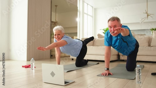 Fitness workout training. Senior adult mature healthy fit couple doing sports exercise on yoga mat on floor at home. Mid age old husband wife have training workout. Health care healthy lifestyle photo