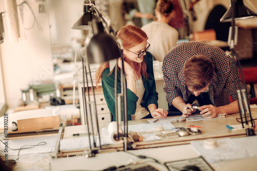 Two young office workers doing a project together