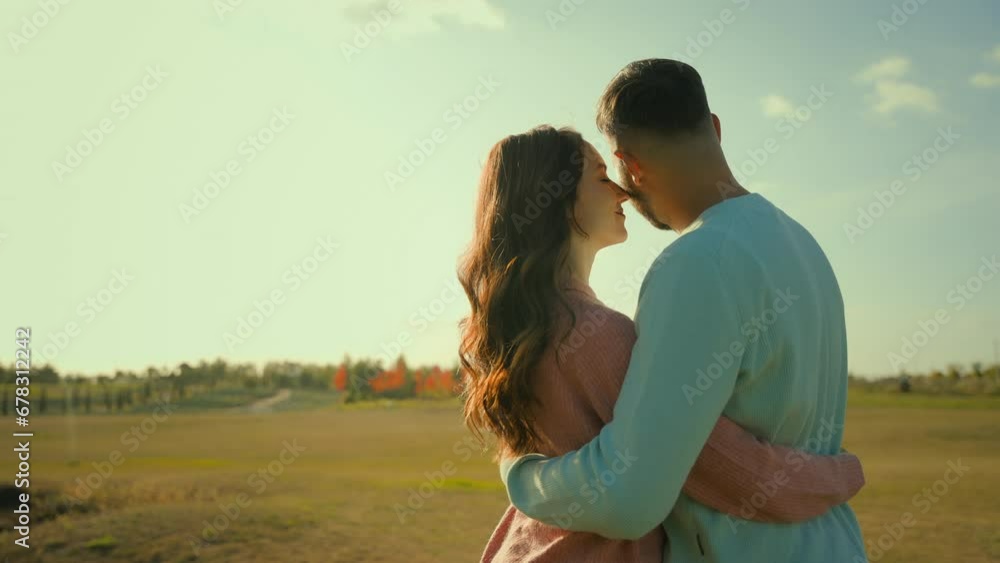 Young loving happy Caucasian married couple wife husband man woman embracing cuddle enjoying leisure weekend together outdoors village countryside field. Harvesting farming ecology environmental care