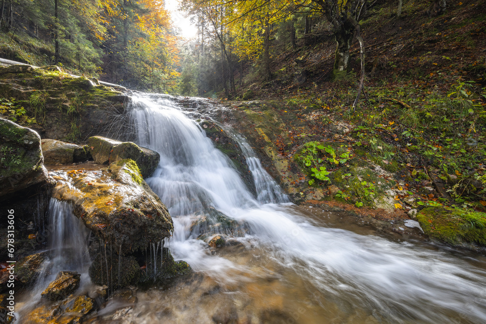 Autumn landscape with waterfall in a beautiful backlight. The rocky gorge Dolne diery in The Mala Fatra National Park, Slovakia, Europe. Autumn landscape with waterfall in a beautiful backlight. The rocky gorge Dolne diery in The Mala Fatra National Park, Slovakia, Europe.
