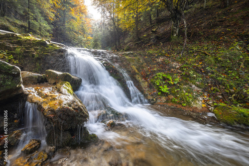 Autumn landscape with waterfall in a beautiful backlight. The rocky gorge Dolne diery in The Mala Fatra National Park, Slovakia, Europe.