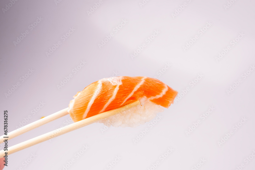 holding a piece of nigiri with chopsticks isolated holding a piece of nigiri with chopsticks isolated