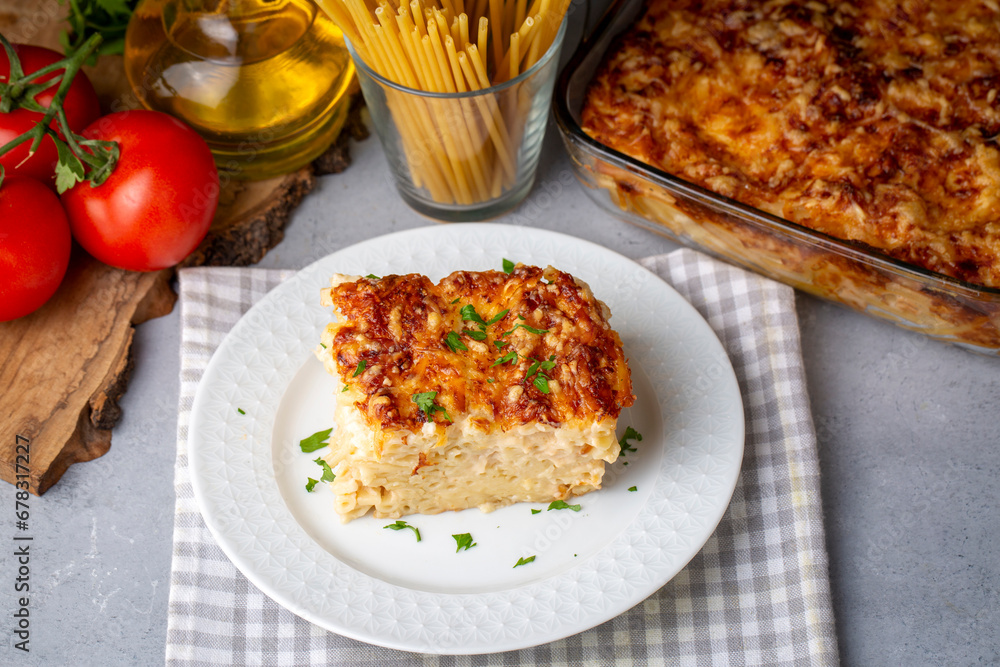 Pasta casserole bechamel sauce topped with melted mozzarella cheese and served in a white baking dish on a table (Turkish name; firinda makarna or firin makarna) Pasta casserole bechamel sauce topped with melted mozzarella cheese and served in a white baking dish on a table (Turkish name; firinda makarna or firin makarna)
