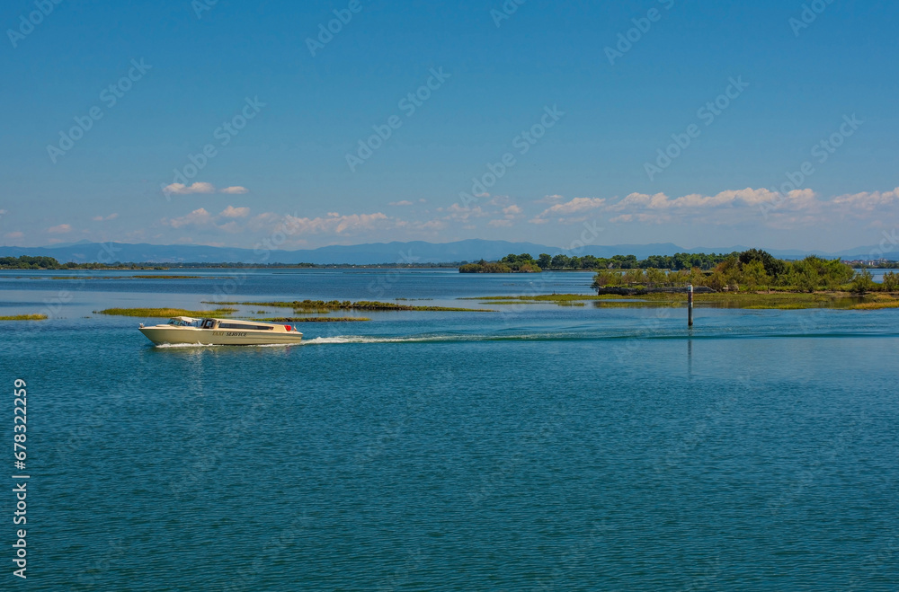 A water taxi crosses the shallow waters of the Grado section of the Marano and Grado Lagoon in Friuli-Venezia Giulia, north east Italy