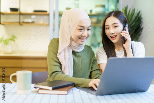 Happy Asian women graduate student discussing and planning a project together.