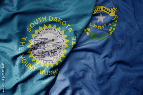 big waving colorful national flag of nevada state and flag of south dakota state . macro photo